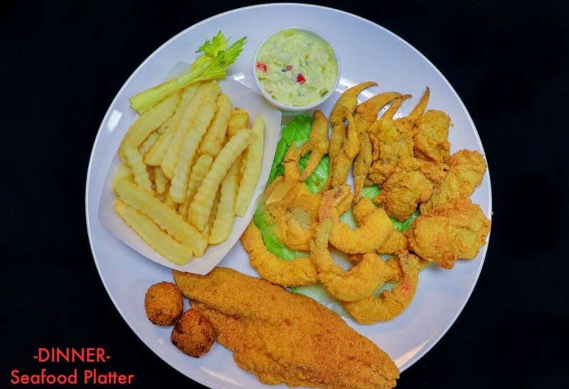 Fried seafood platter with fish, shrimp, fries and hush puppies